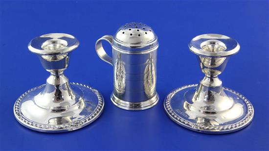 An Edwardian silver pepper pot by Edward Barnard & Sons Ltd & pair of candlesticks.